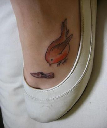 Tiny orange bird tattoo