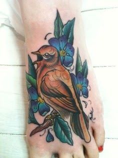 Foot tattoo with bird and blue flowers