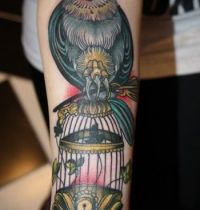 Bird on birdcage tattoo