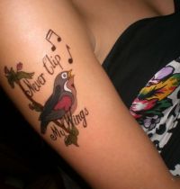 Tattoo with bird on the branch with notes