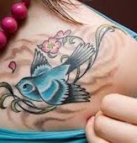 Blue and black bird tattoo