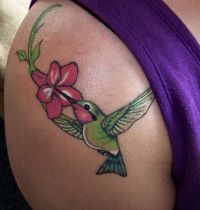 Green hummingbird and flower tattoo