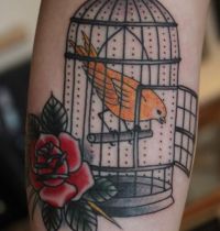 Orange bird in birdcage tattoo