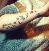 Small birds as arm tattoo