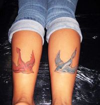 Two swallow tattoo on calfs