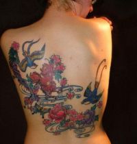 Two swallows among flowers tattooo