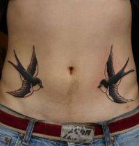 Tattoo with two swallows on belly