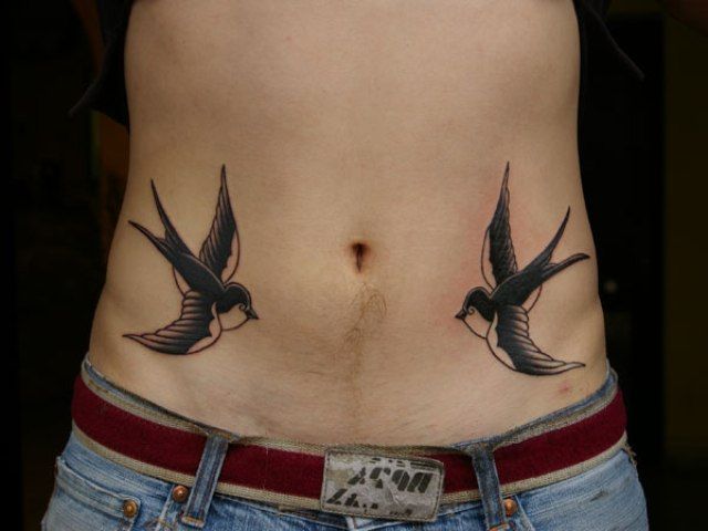 Tattoo with two swallows on belly